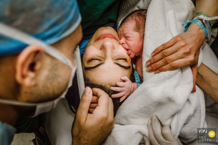 Istanbul Birth Photography of the first kiss from newborn to mom at Acibadem Bakirkoy