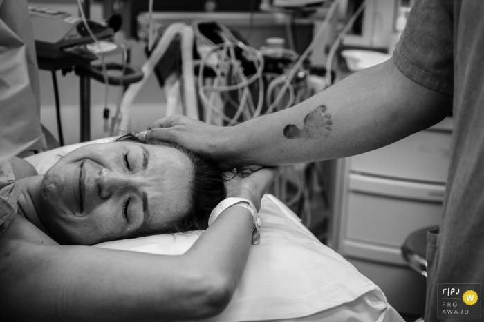 Photo by: <a href="https://www.fpja.com/documentary-family-photography-contests/cibele-barreto-mendes/sao-paulo/2107986">Cibele Barreto Mendes - Brazil</a> Hospital Israelita Albert Einstein birth picture of the father giving support to the mother
