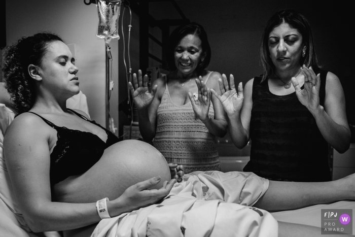 Photo by: <a href="https://www.fpja.com/documentary-family-photography-contests/lisandro-castro/cuiab%C3%A1/2107998">Lisandro Castro - Brazil</a> Hospital Santa Rosa birth image of family praying over the mother in labor