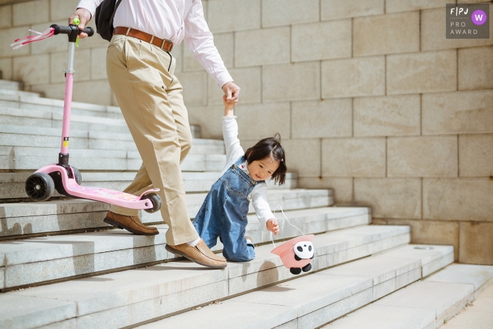 Photo by: <a href="https://www.fpja.com/documentary-family-photography-contests/bai-gang/shanxi/2106712">Bai Gang - China</a> Shanxi Family Image of little girl accidentally falling down the stairs trying to catch her hat
