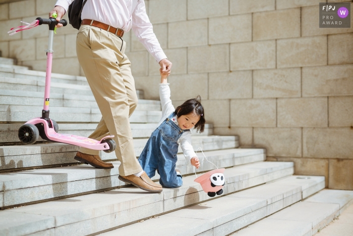 Shanxi Family Image of little girl accidentally falling down the stairs trying to catch her hat