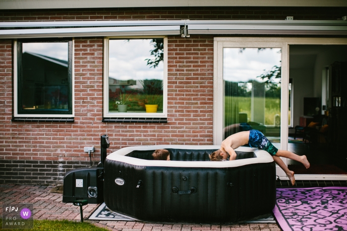 Photo by: <a href="https://www.fpja.com/documentary-family-photography-contests/jolanda-boer/drenthe/2107109">Jolanda Boer - Netherlands</a> Drenthe Documentary Family picture of a boy taking a dive in the jacuzzi on sunday-morning