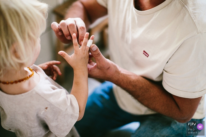 Photo by: <a href="https://www.fpja.com/documentary-family-photography-contests/jolanda-boer/drenthe/2107126">Jolanda Boer - Netherlands</a> Drenthe Documentary Family image of dad taking care of the hurt finger
