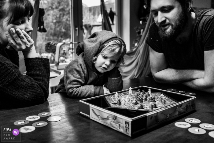 Photo by: <a href="https://www.fpja.com/documentary-family-photography-contests/polina-subbotina/hamburg/2107289">Polina Subbotina - Germany</a> Hamburg Family playing a game on the table