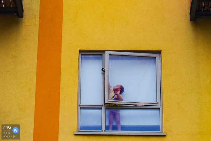 Dusseldorf Documentary Family picture of a young toddler attempting to drop his shoe out the window