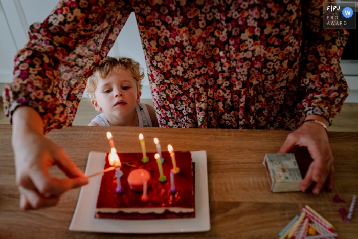 Photo by: <a href="https://www.fpja.com/documentary-family-photography-contests/florent-cattelain/haute-garonne/2107642">Florent Cattelain - France</a> Occitanie Documentary Family Photography | boy watches the birthday cake and the candles are lit