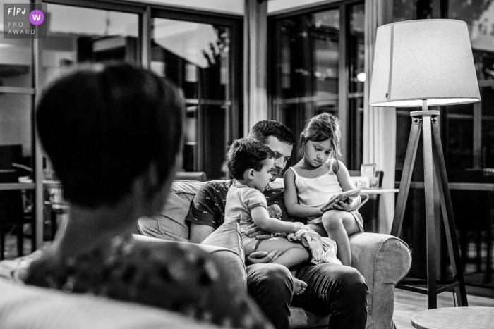 Photo by: <a href="https://www.fpja.com/documentary-family-photography-contests/florent-cattelain/haute-garonne/2107646">Florent Cattelain - France</a> Haute-Garonne Documentary Family Image of dad reading a bedtime story to his children