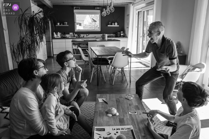 Savoie Documentaire Photo de Famille | Un papa fait un mime pendant un jeu de société