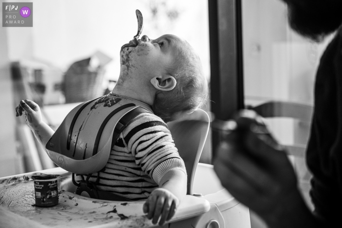 Savoie Documentary Family Photographer | A little boy fooling around with his spoon during the meal 