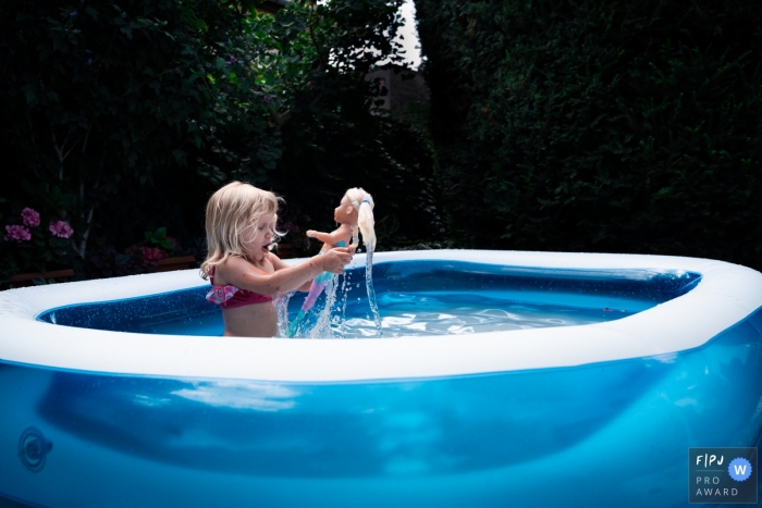 Nimes Documentary Family Photography | girl in the pool with her doll