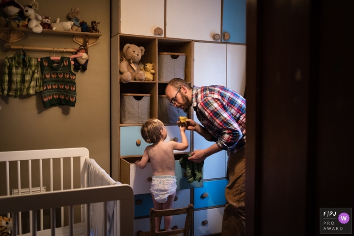 Photo by: <a href="https://www.fpja.com/documentary-family-photography-contests/alice-chapman/cambridgeshire/2107838">Alice Chapman - United Kingdom</a> Cambridgeshire Family photography of a toddler in his drawers pulling out socks