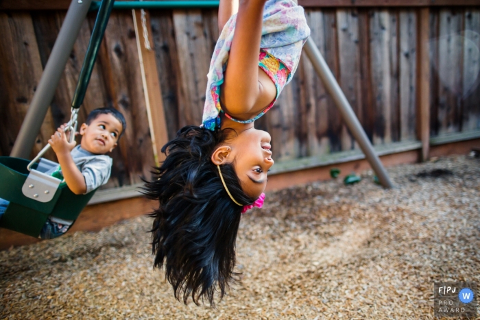 San Francisco Documentary Family Photo of two siblings playing on a swingset