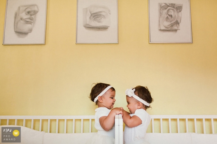 Saint-Petersburg family photo of two toddlers facing each other in their separate cribs side-by-side