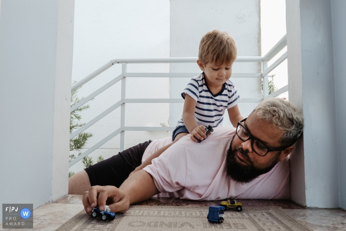 Photo by: <a href="https://www.fpja.com/documentary-family-photography-contests/thiago-braga/florianopolis/2108221">Thiago Braga - Brazil</a> Florianopolis image of Father playing with his son with toy car