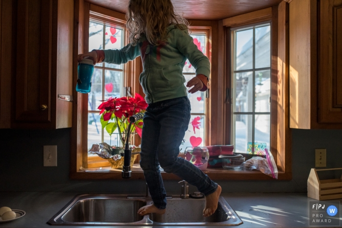 Connecticut Documentary Family photo of Young girl running across the counters making breakfast 