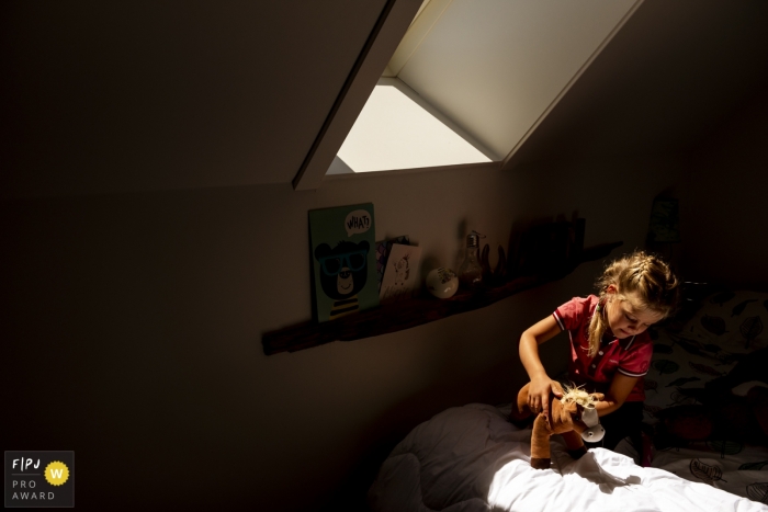 Netherlands Family Photography | young girl playing with a stuffed horse in her room