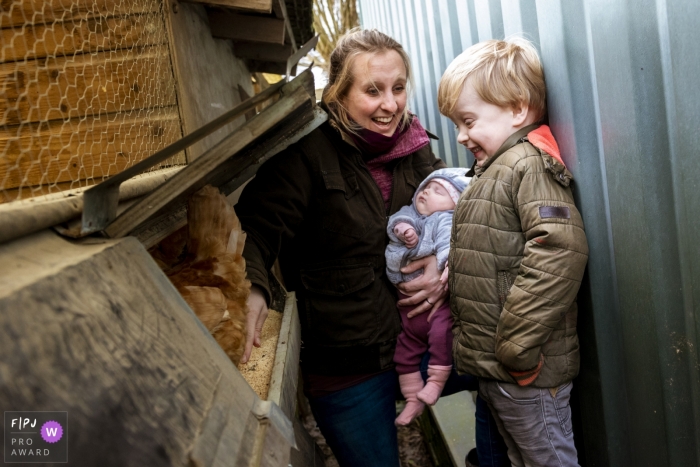 Netherlands Family Photography showing a boy looking in wonder when finding a chicken egg in the nest Netherlands Family Photographer | boy looking in wonder when finding a chicken egg in the nest