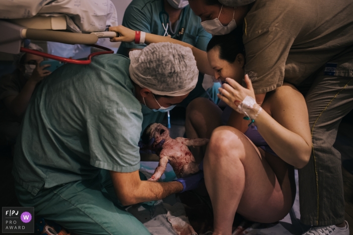 Photo by: <a href="https://www.fpja.com/documentary-family-photography-contests/ivete-siqueira-da-franca-bueno/sao-paulo/2109189">Ivete Siqueira da Franca Bueno - Brazil</a> SP hospital birth pictures from a photo session at Maternidade São Luis Itaim Bibi of mother giving birth with assistants surrounding her