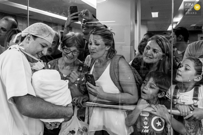 Photo by: <a href="https://www.fpja.com/documentary-family-photography-contests/liliane-cotta/rio-de-janeiro/2109381">Liliane Cotta - Brazil</a> RJ family pictures from a hospital birth photo shoot at Maternidade Perinatal of a father at the nursery introducing his new baby to the family