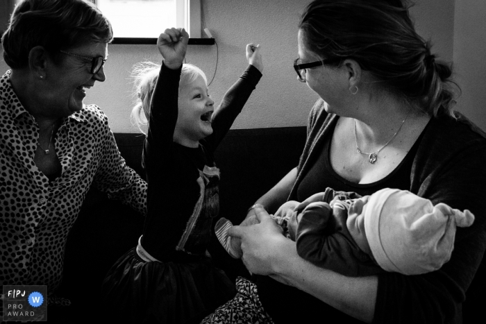 Photo by: <a href="https://www.fpja.com/documentary-family-photography-contests/bianca-van-den-berg/overijssel/2109605">Bianca Van den berg - Netherlands</a> NL family and birth photography in black and white of big sister meeting her new baby brother with extreme excitement