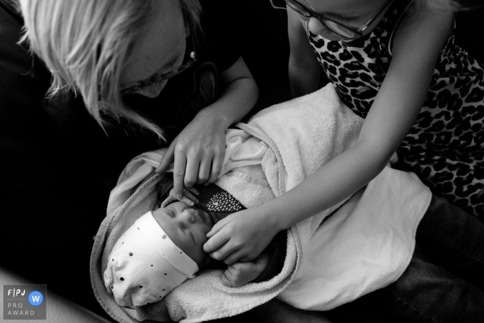 Photo by: <a href="https://www.fpja.com/documentary-family-photography-contests/bianca-van-den-berg/overijssel/2109657">Bianca Van den berg - Netherlands</a> Overijssel Family photography of a brother and sister meeting their new baby sister