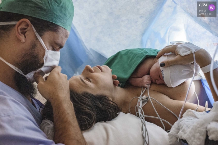 Perinatal Laranjeiras birth photograph of a new baby laying on his mother's chest as the new parents feel overwhelming emotion