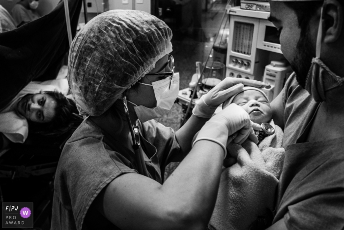 Brazil in-hospital baby and birth photography showing a masked health care working checking heartbeat of the baby