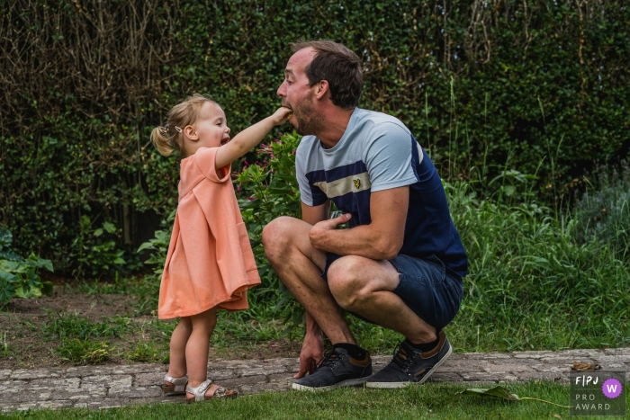 Belgium Family photographer captures this young girl feeding a cookie to her dad Belgium Family photographer captures this young girl feeding a cookie to her dad