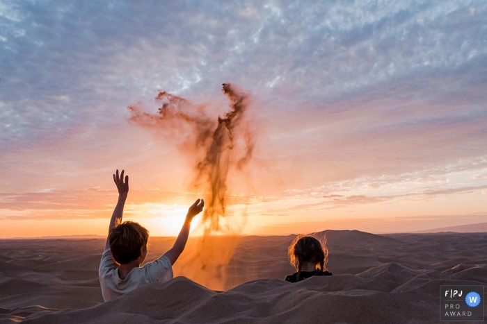 A Belgium documentary-style family photography session at the beach during sunset of kids sitting in dug-out holes in the sand