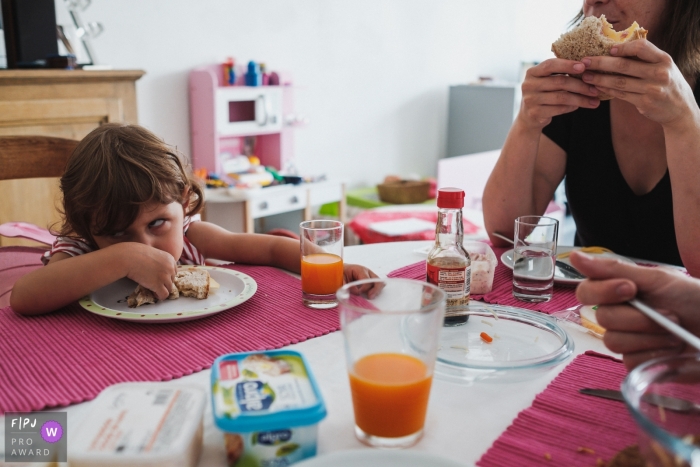 Antwerpen family photographer documents a young girl girl rolling her eyes at the breakfast table in Belgium Antwerpen family photographer documents a young girl girl rolling her eyes at the breakfast table in Belgium