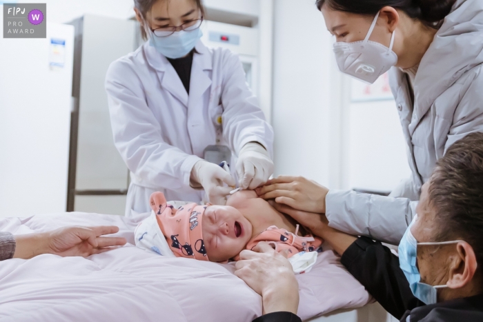 China documentary-style baby photography session of a newborn receiving a vaccine at the hospital in Shanxi China documentary-style baby photography session of a newborn receiving a vaccine at the hospital in Shanxi