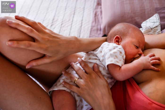 MG baby nursing pictures from an at-home photo session of mother and child are in a similar position during breastfeeding in the first days of life in Brazil MG baby nursing pictures from an at-home photo session of mother and child are in a similar position during breastfeeding in the first days of life in Brazil