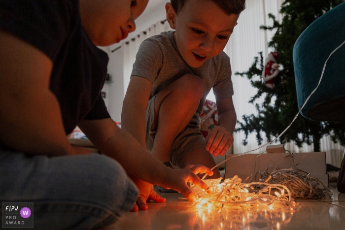 Photo by: <a href="https://www.fpja.com/documentary-family-photography-contests/lukinha-arruda/arapongas/2109180">Lukinha Arruda - Brazil</a> Panara family holiday photography showing the excitement from children with Christmas lights in Brazil