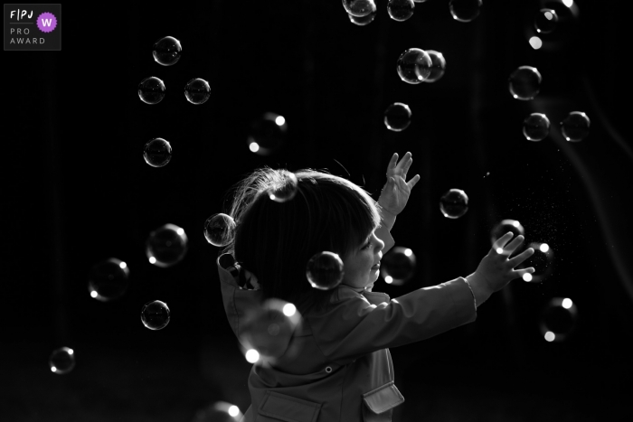 Photo by: <a href="https://www.fpja.com/documentary-family-photography-contests/joshua-dhondt/antwerpen/2109753">Joshua Dhondt - Belgium</a> Antwerp black and white family photography with endless, timeless soap bubbles
