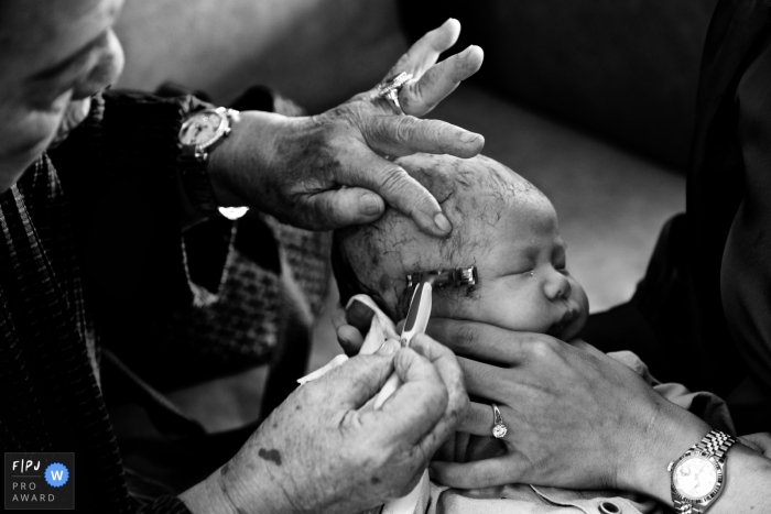 Thailand baby pictures from an at-home photo shoot of a one month old baby getting his head shaved by his great grandma in Bangkok