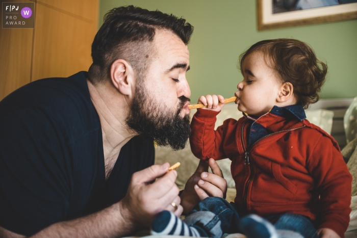 Athens in-home family photography from Attica with a father and son sharing a snack Athens in-home family photography from Attica with a father and son sharing a snack