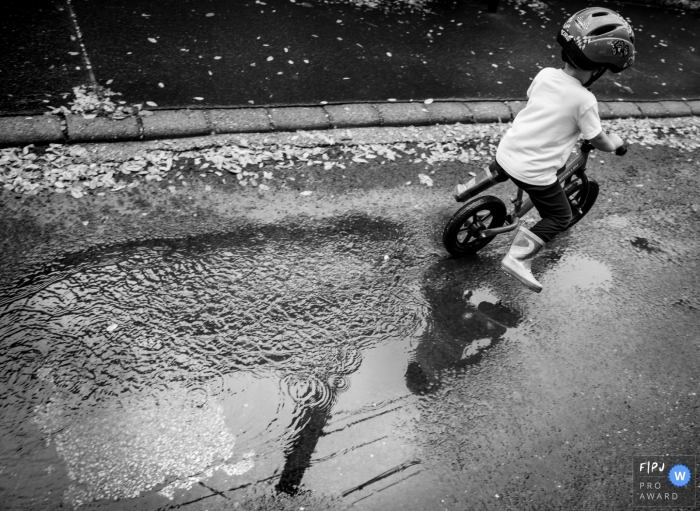 Photo by: <a href="https://www.fpja.com/documentary-family-photography-contests/gabriella-feyer/nimes/2109971">Gabriella Feyer - France</a> Nimes black and white outdoor family pictures from an at-home photo shoot in Gard with a biking kid in boots