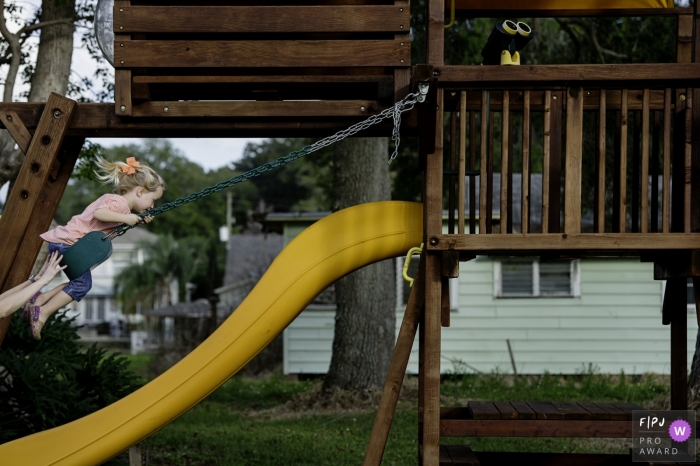 Key West, FL family image shoot in the backyard of the home with a girl who Just keeps swinging