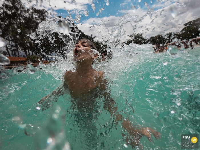 SP summer-time family pictures from a photo shoot with a kid swimming in the water while surrounded by joy