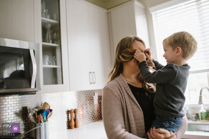 Young boy covers his mom's eyes with her hair in this Los Angeles Family photo