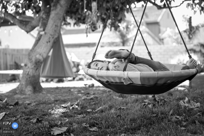Photo by: <a href="https://www.fpja.com/documentary-family-photography-contests/loren-haar/ventura/2110312">Loren Haar - United States</a> Ventura, CA family photographer captures these two brothers on the swing hugging