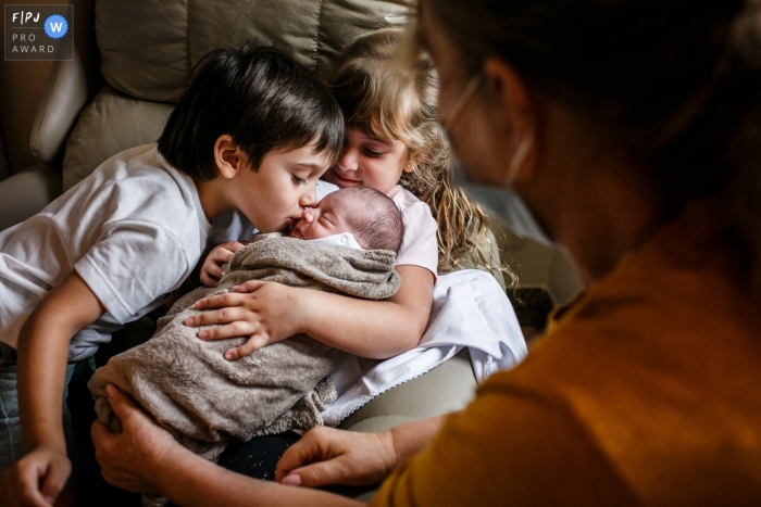 Photo by: <a href="https://www.fpja.com/documentary-family-photography-contests/adriana-costa/belo-horizonte/2110621">Adriana Costa - Brazil</a> Minas Gerais at home birth photography showing the First kiss between siblings right after birth