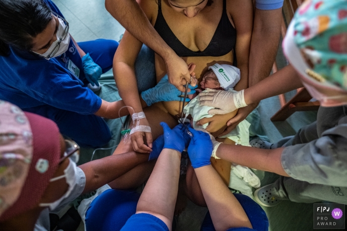 Photo by: <a href="https://www.fpja.com/documentary-family-photography-contests/lisandro-castro/cuiab%C3%A1/2111363">Lisandro Castro - Brazil</a> Maternidade Femina hospital documentary birth photography showing A support circle taking care of the baby that was just born