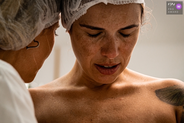 Photo by: <a href="https://www.fpja.com/documentary-family-photography-contests/liliane-cotta/rio-de-janeiro/2111473">Liliane Cotta - Brazil</a> Maternidade Perinatal Laranjeiras hospital birth image using a documentary-style of a mom thrilled during the application of anesthesia just before the birth of her first daughter