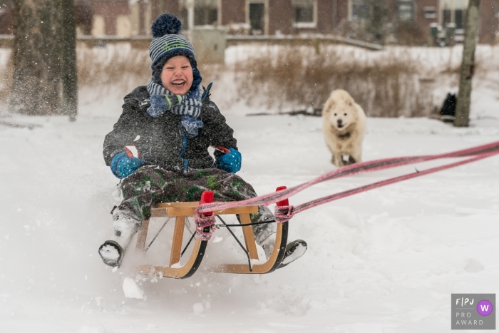 Photo by: <a href="https://www.fpja.com/documentary-family-photography-contests/louise-van-den-broek/flevoland/2110421">Louise van den Broek - Netherlands</a> Flevoland at home Day in the Life photography with a kid and dog Having fun in the snow