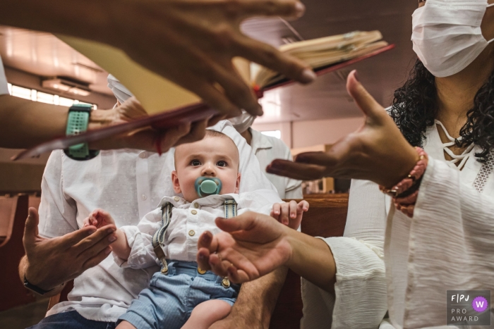 Campo Grande Baptism Session of documentary family photography showing the child observing everything during his baptism mass