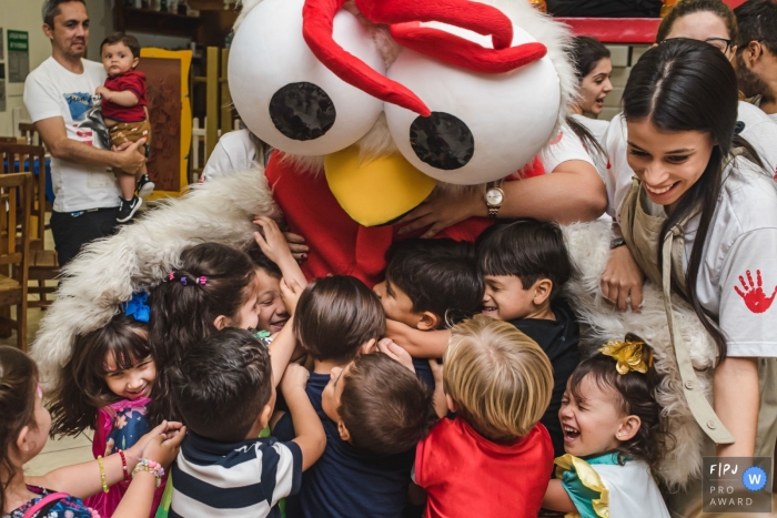 Campo Grande Day in the Life Session of documentary family photography Raised in a group hug with the rooster mascot of the party house