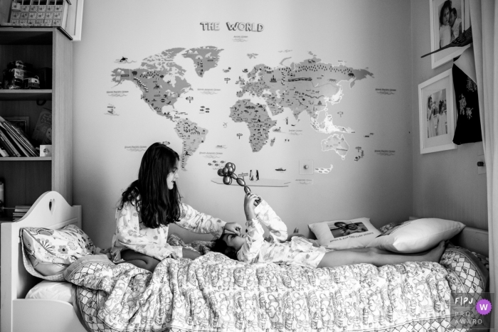 Photo by: <a href="https://www.fpja.com/documentary-family-photography-contests/ana-ruivo/london/2111002">Ana Ruivo - United Kingdom</a> Day in the Life photography session at home in London with sisters playing in bed