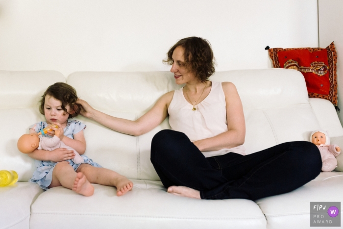 Photo by: <a href="https://www.fpja.com/documentary-family-photography-contests/marine-poron/paris/2111271">Marine Poron - France</a> Ile-de-France Day in the Life Session of documentary family photography showing the mom and her daughter bottle-feeding the doll
