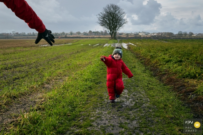 Séance de photographie familiale documentaire Day in the Life en Angleterre montrant un enfant disant Attends-moi